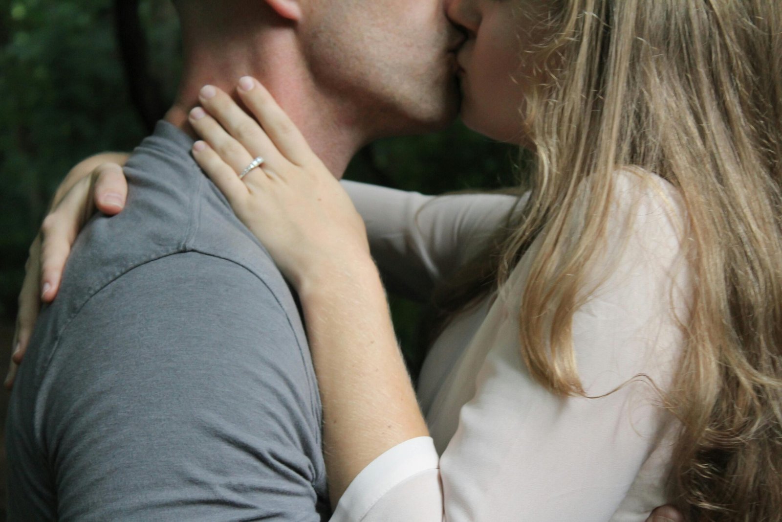 Close-up of a couple kissing outdoors, highlighting love and affection.