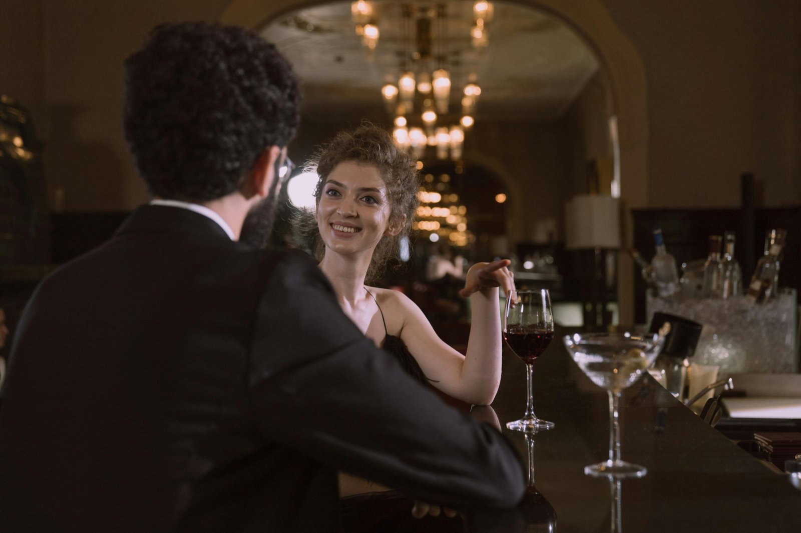 Sophisticated couple enjoys an intimate evening with red wine and cocktails at an upscale bar.