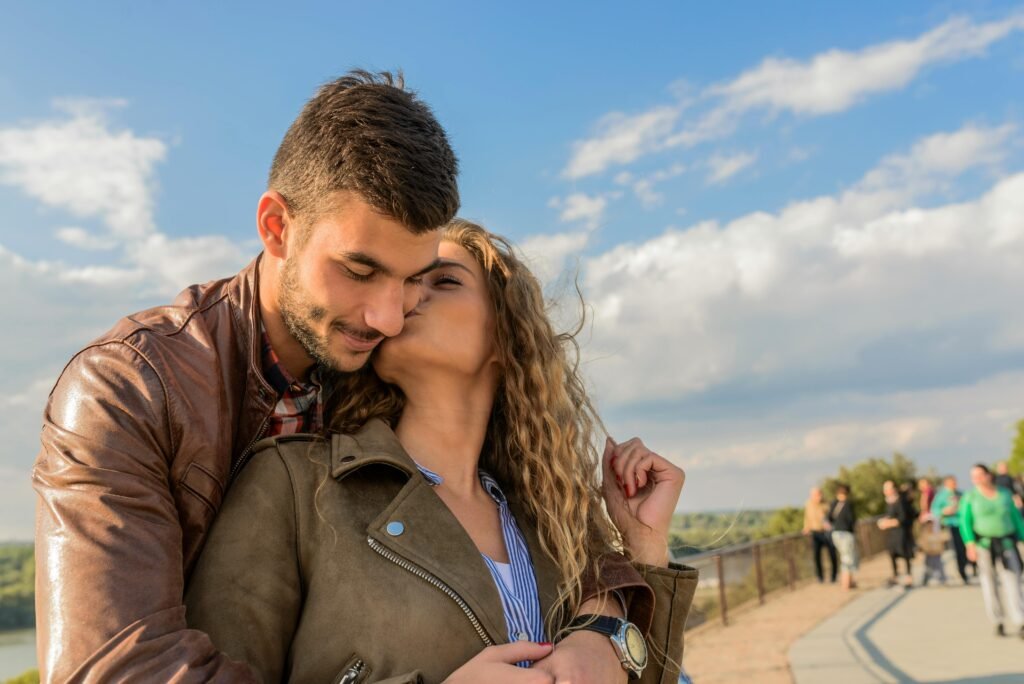 A loving couple embraces under a clear sky, showcasing romance and togetherness.