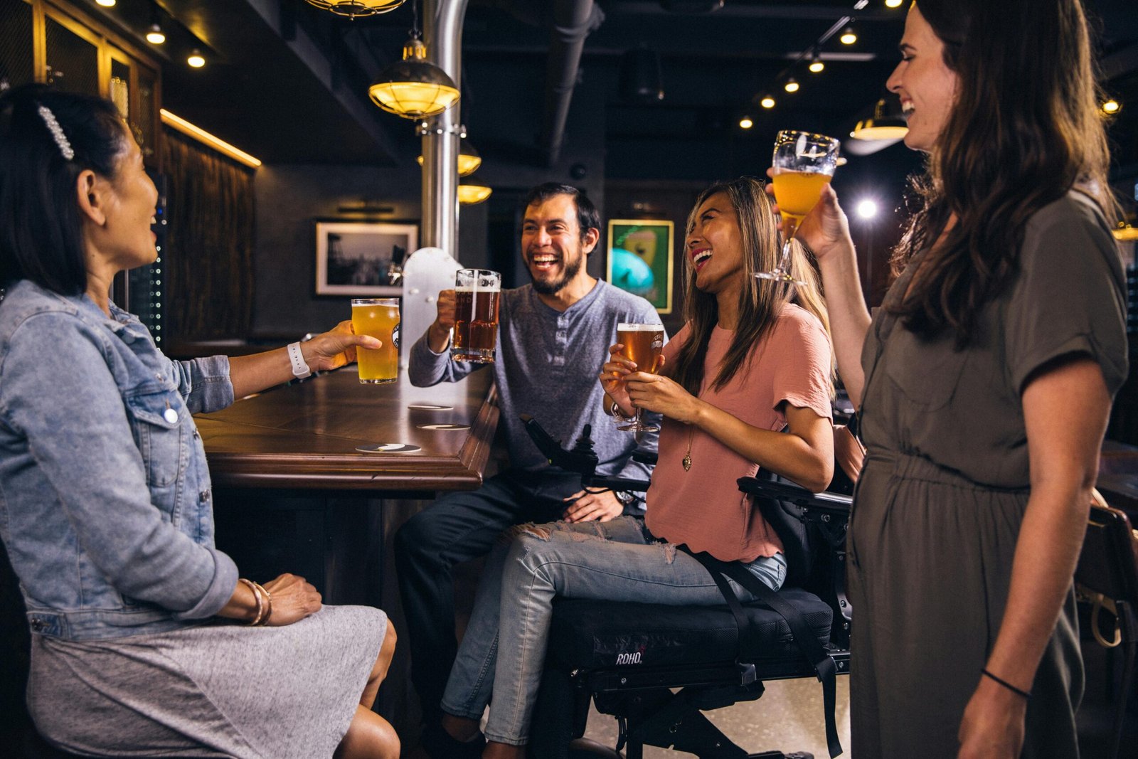 Friends sharing a joyful moment with drinks in a cozy bar setting.